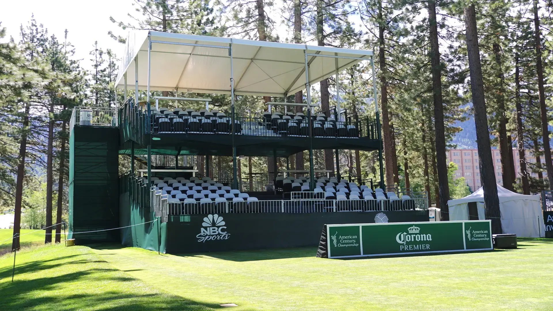 InProduction shaded multi-level hospitality structure with padded seating installed for the American Century Championship, providing clear sightlines across the Lake Tahoe course.
