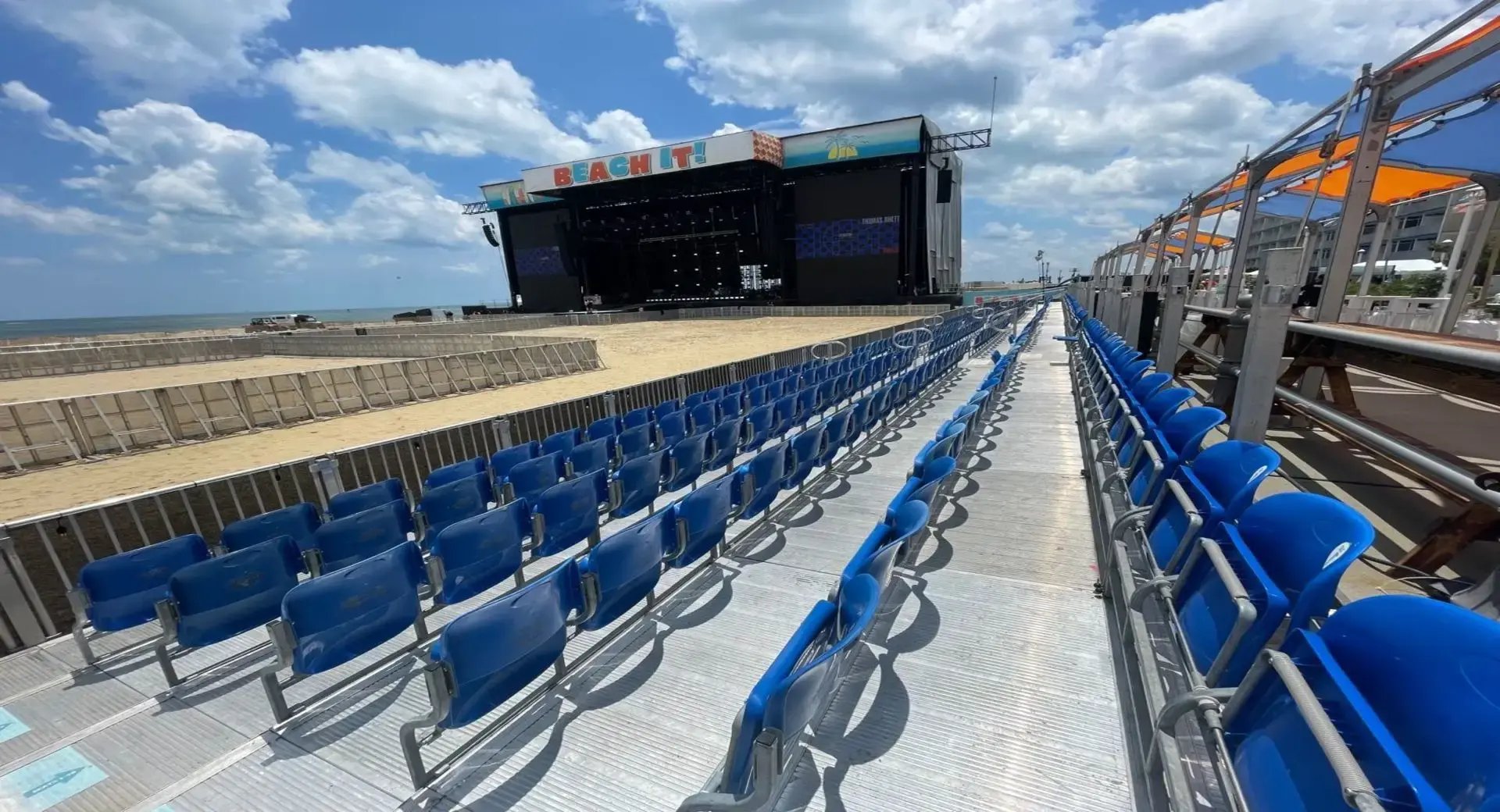 InProduction tiered seating installed on the sand at the Beach It! Festival, providing clear sightlines and a premium viewing experience toward the main stage.