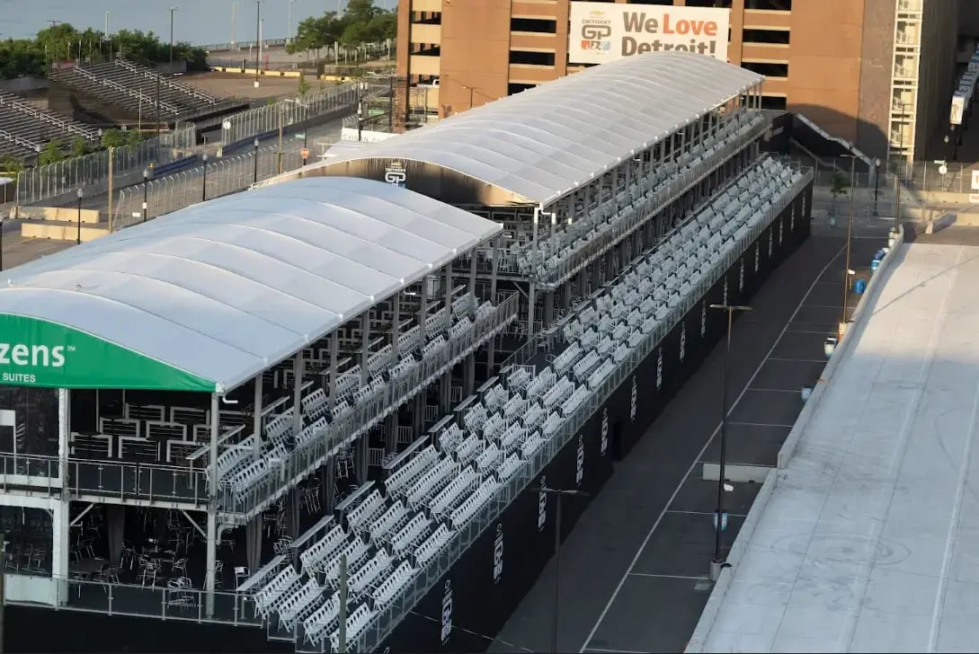 InProduction two-level hospitality structure with integrated seating installed for the Chevrolet Detroit Grand Prix, offering elevated views of the Detroit River and skyline.