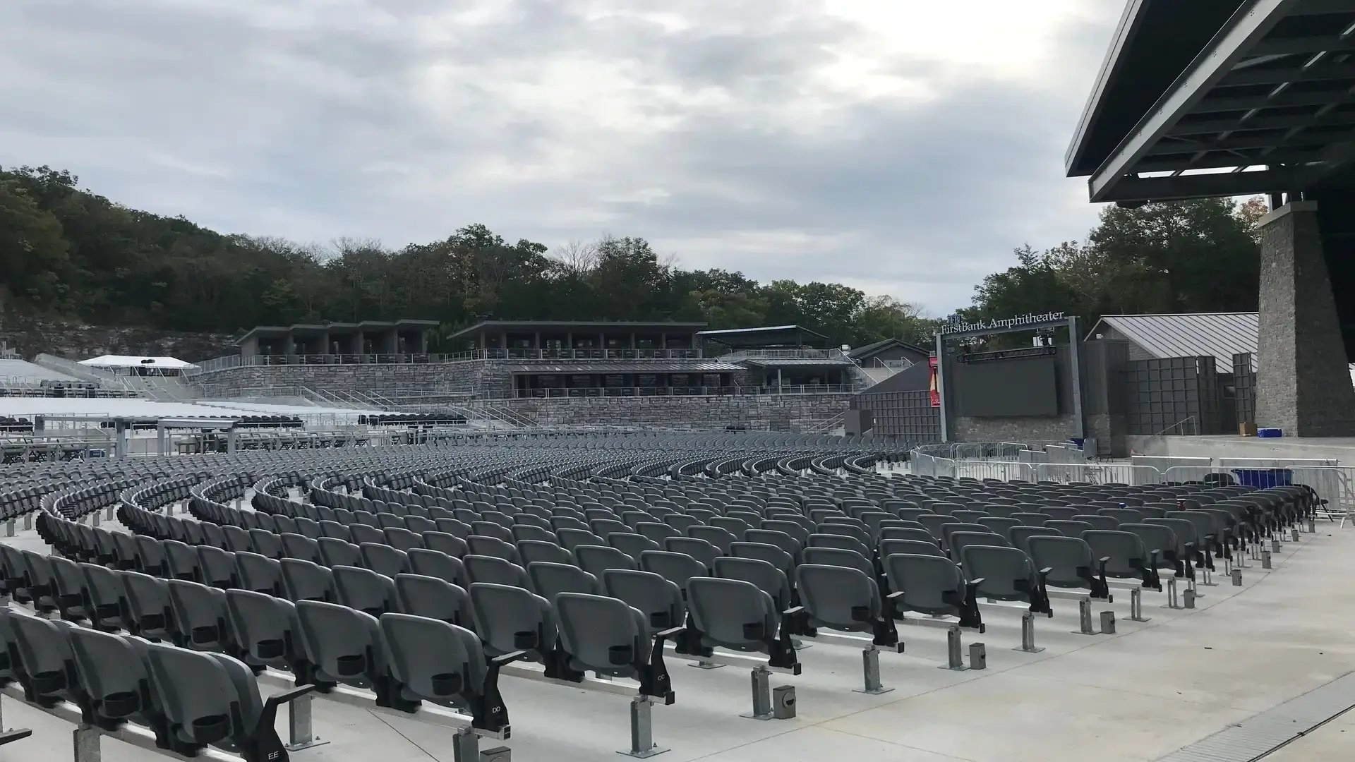 InProduction amphitheater seating at FirstBank Amphitheater installed within a dramatic rock quarry setting, featuring VIP chairs, backed benches, and standard seating mounted into concrete.