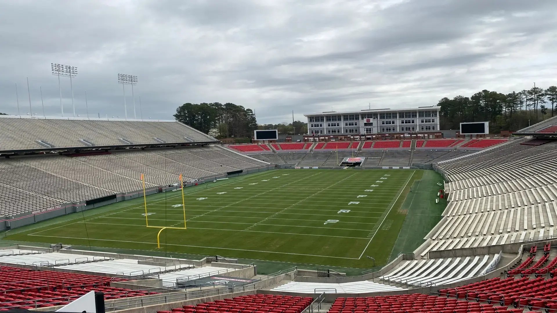 InProduction supplemental grandstand seating with custom mesh branding installed at NC State University’s Carter–Finley Stadium to enhance capacity and overall fan experience.