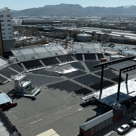 Outdoor amphitheater with tiered seating and stage set in a natural setting.