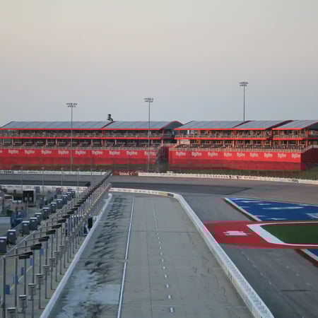 Custom grandstands seen from the pit lane of a race track.