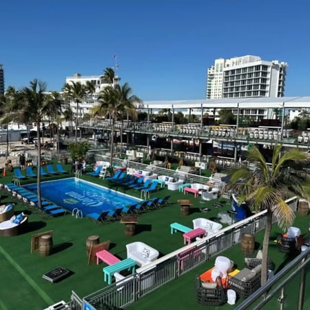 Poolside temporary stage with multi-level seating and lounge area for a music event