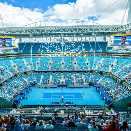 View from upper seating of a large tennis stadium with video screens